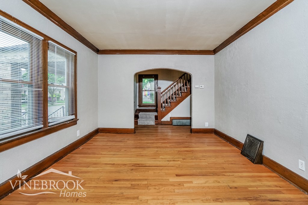 a living room with a hard wood floor and a staircase