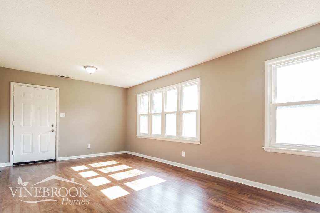 the living room of a home with a hardwood floor and a white door