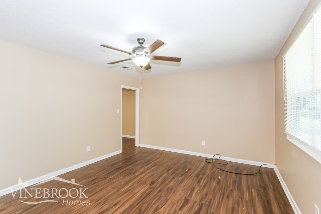 a living room with hardwood floors and a ceiling fan