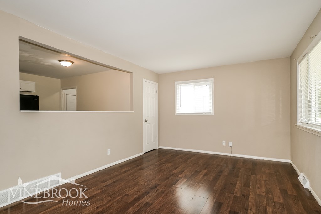 a living room with a hard wood floor and a large mirror