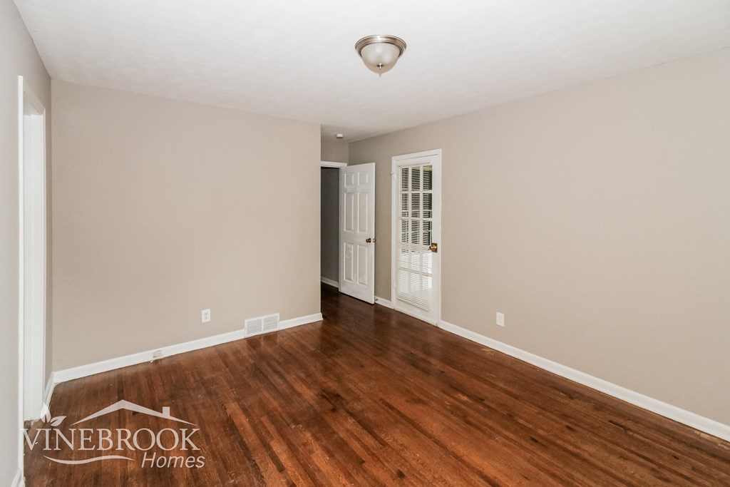 A room with wooden floors and a white ceiling with a light fixture.