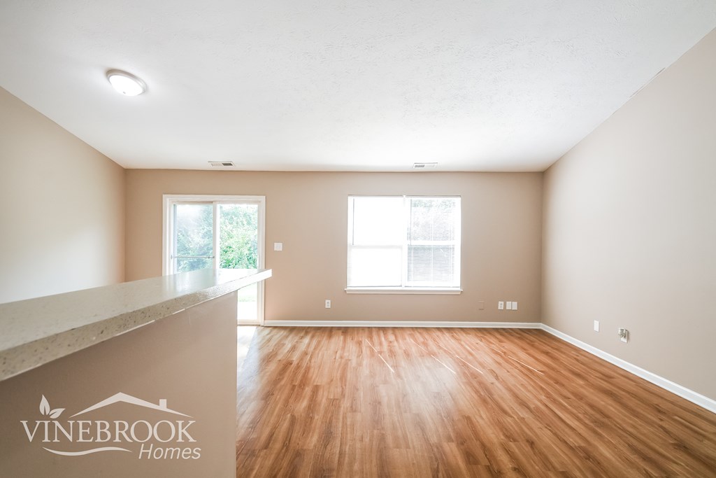 the living room and dining room of a house with wood flooring