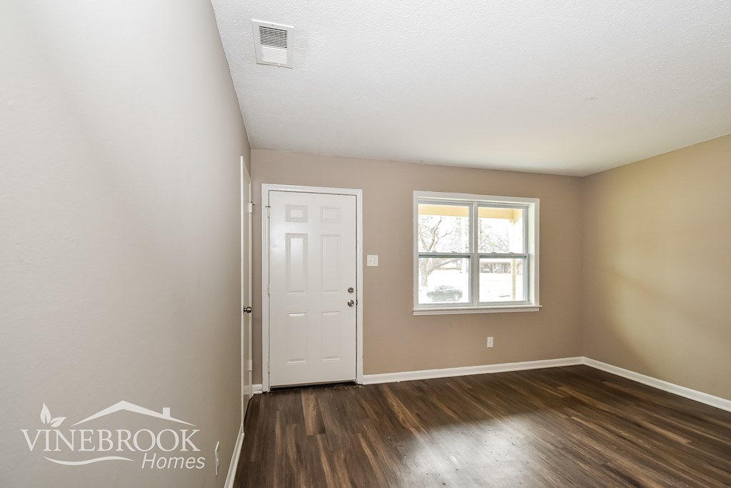 A room with a white door and a window with a Vinebrook Homes logo.