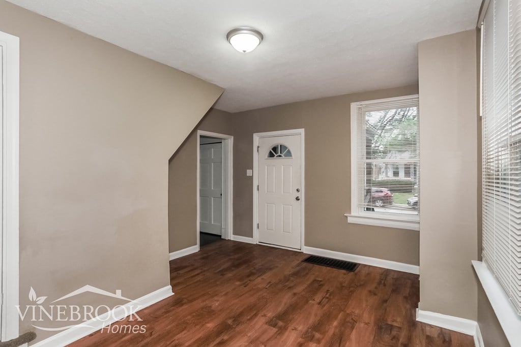 A room with a white door and a window with blinds.