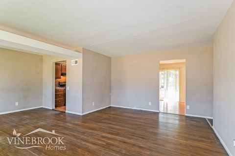 A room with wood flooring and a logo that says Vinebrook Homes.