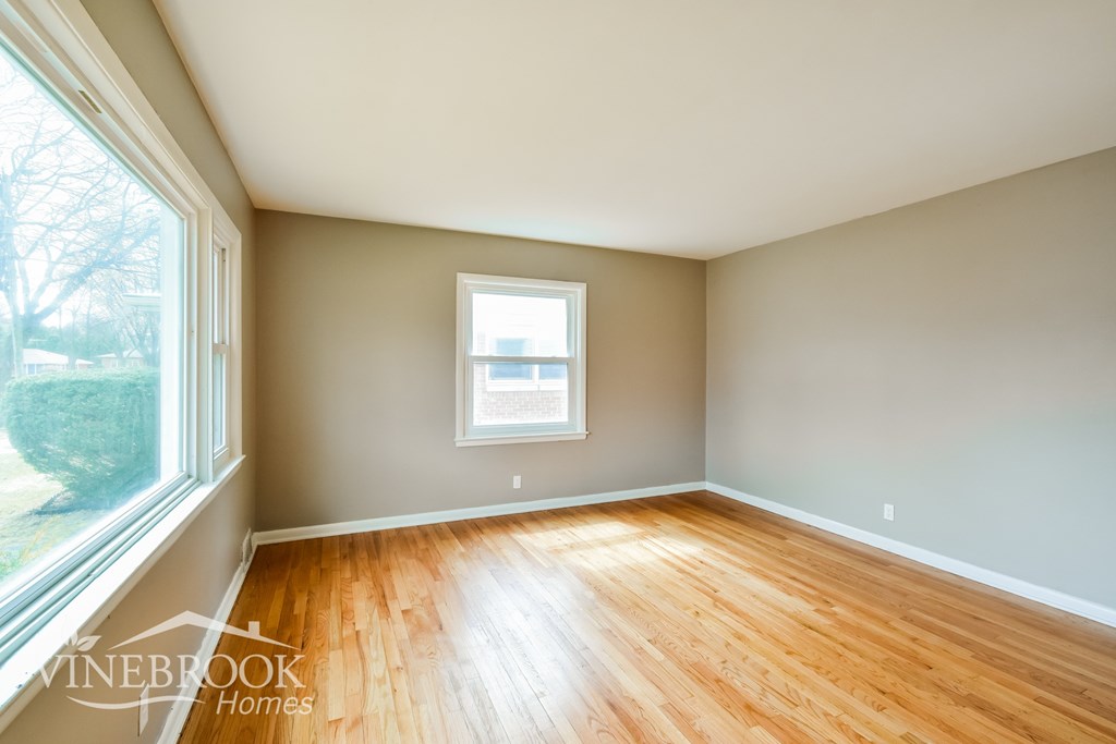 A room with a window and wooden floors.