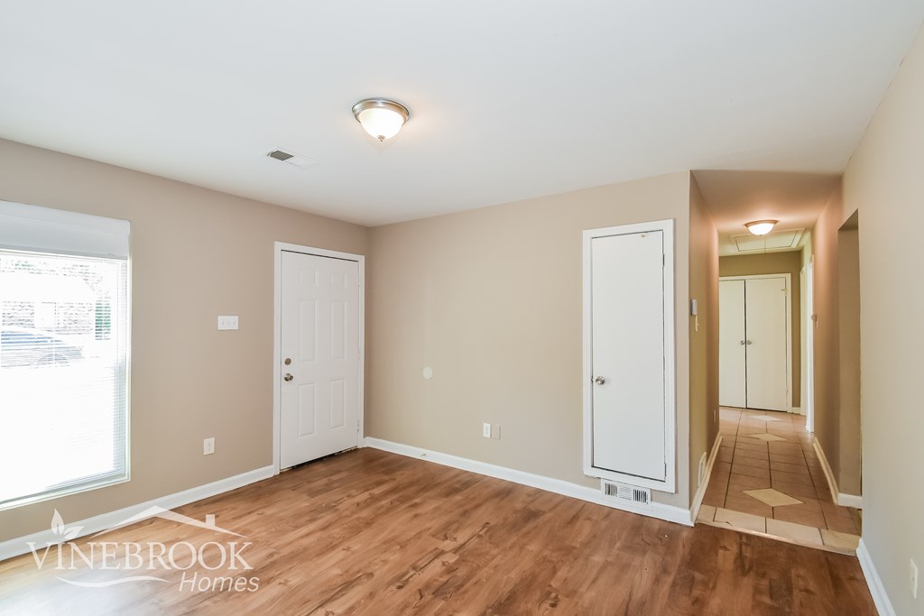 A room with wood flooring and white doors is shown.