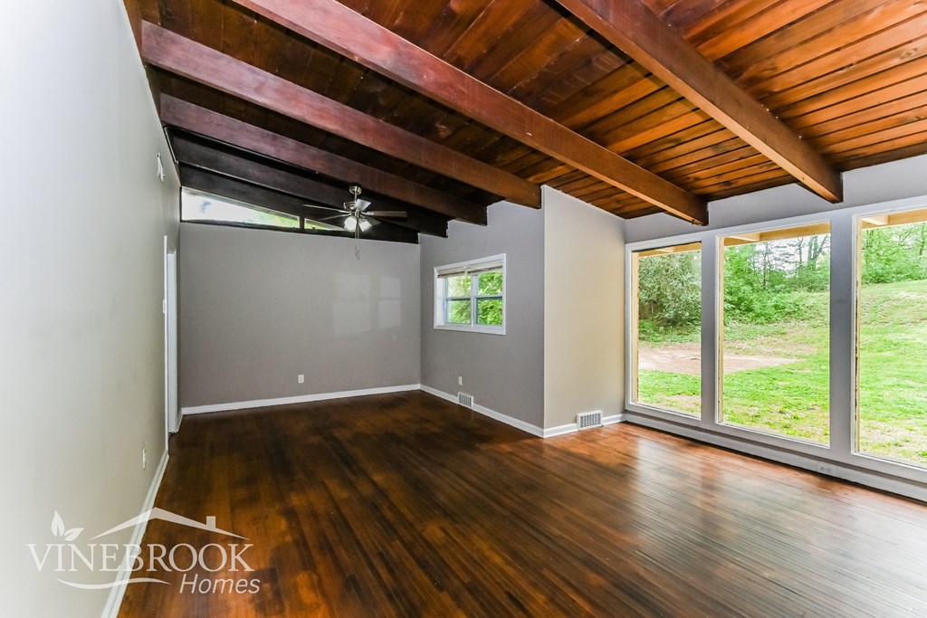 A room with wooden floors and a ceiling with wooden beams.