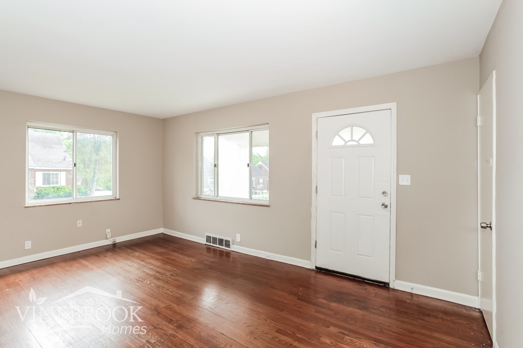 A room with a white door and two windows.