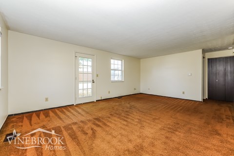 A room with a carpeted floor and a logo that says Vinebrook Homes.
