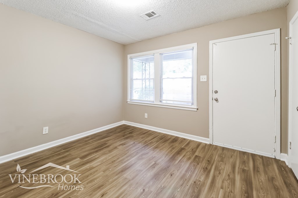 A room with a wooden floor and a white door.