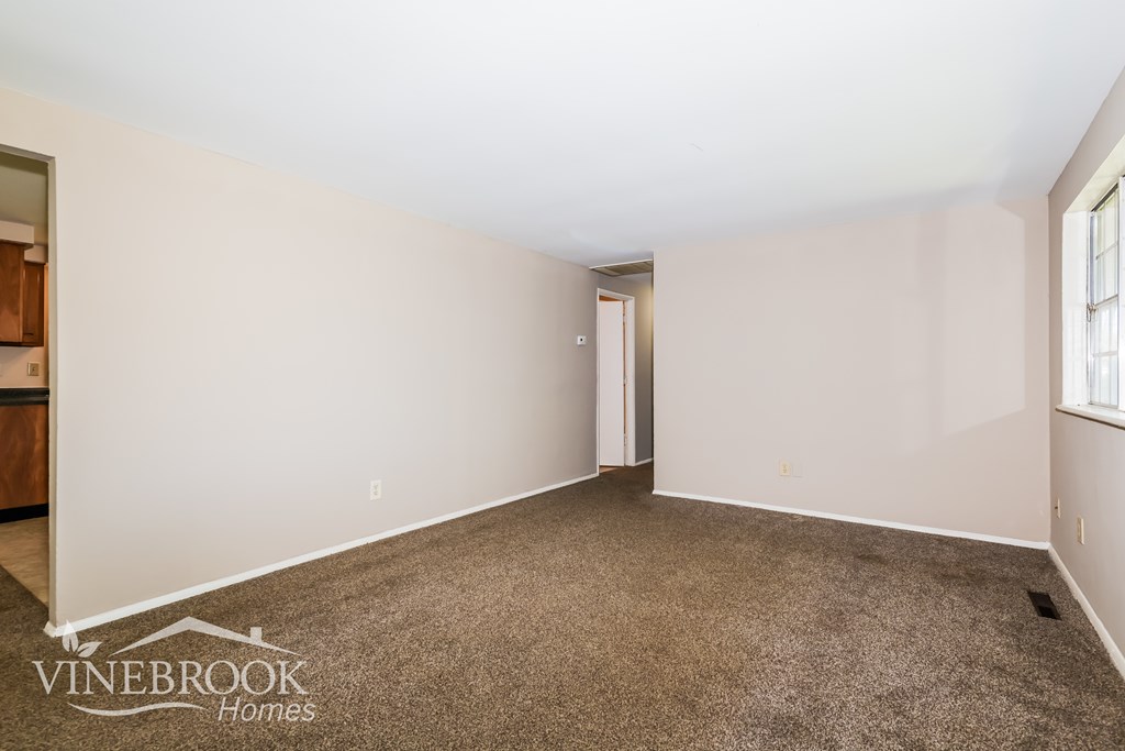 A room with a carpeted floor and a door in the middle.