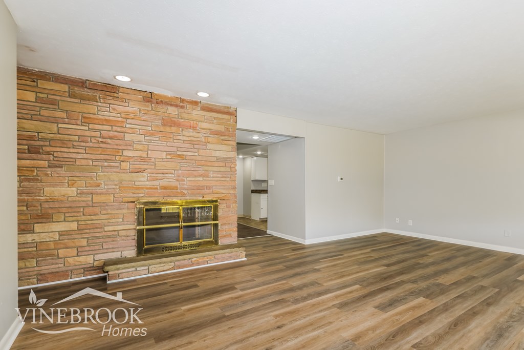 A room with a brick wall and wooden flooring.