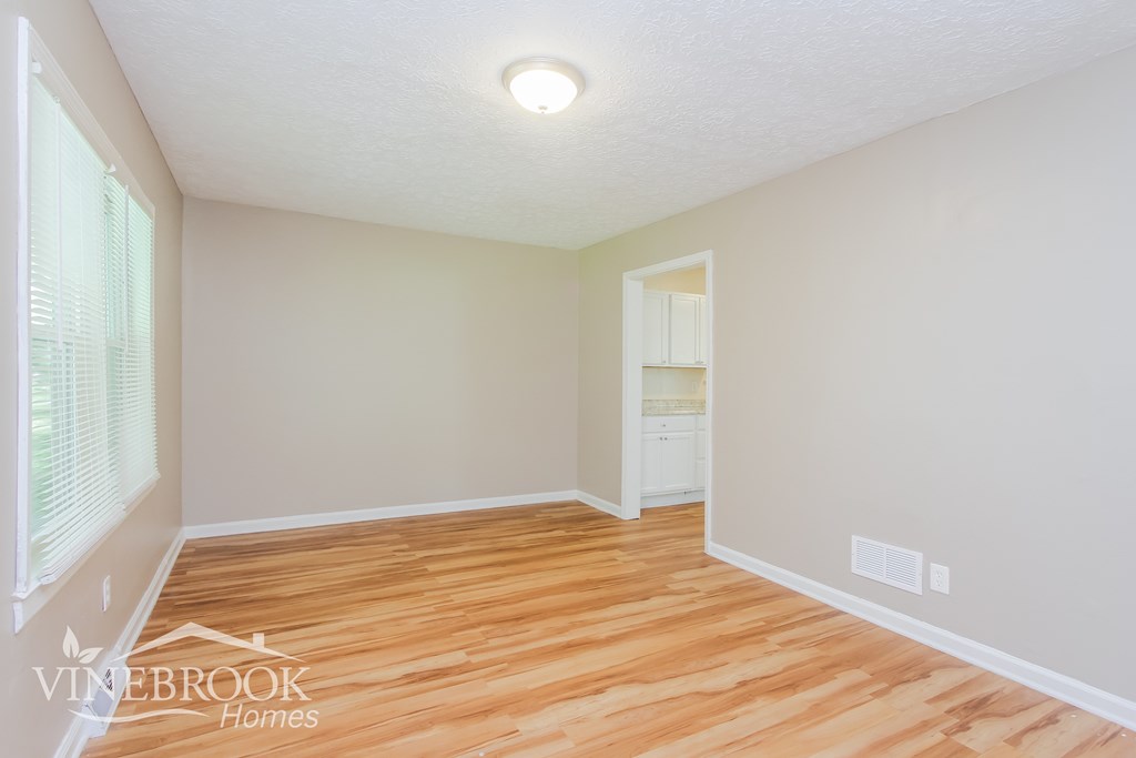 A room with wood flooring and a white ceiling.