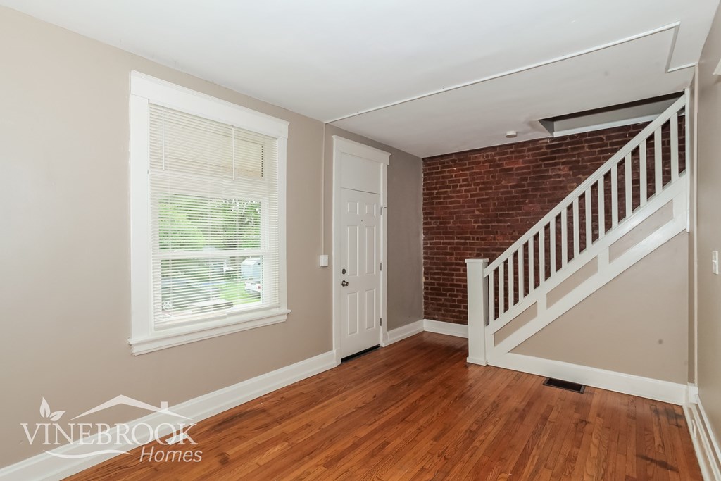A room with a wooden floor and a brick wall.