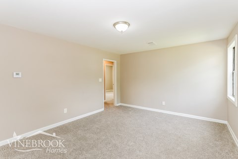 A room with a carpeted floor and a door in the middle.