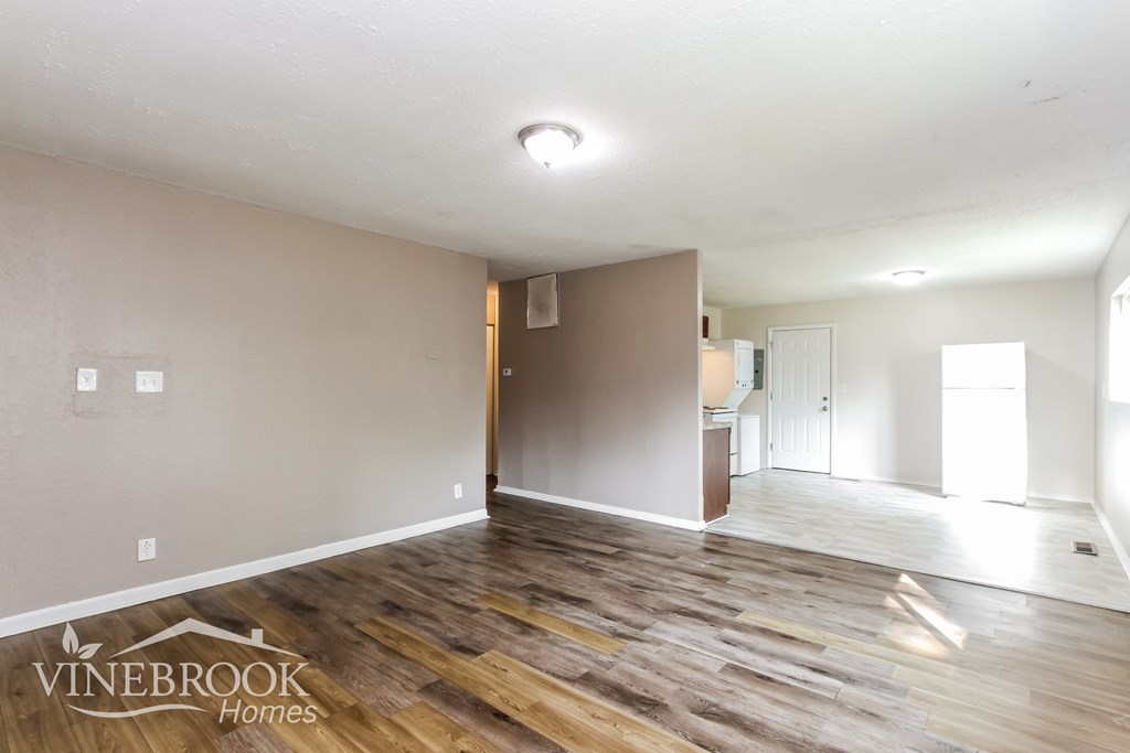 A room with wooden flooring and a Vinebrook Homes logo.