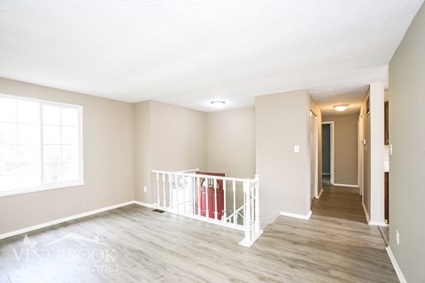 A room with a white railing and a window.