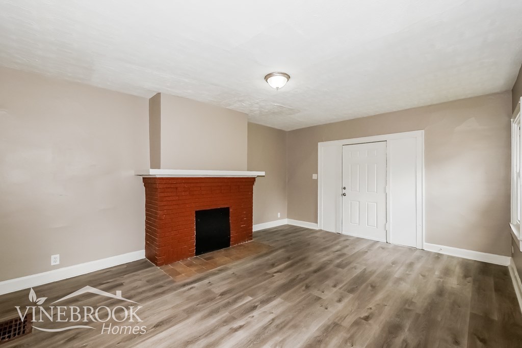 A room with a fireplace and a wooden floor.