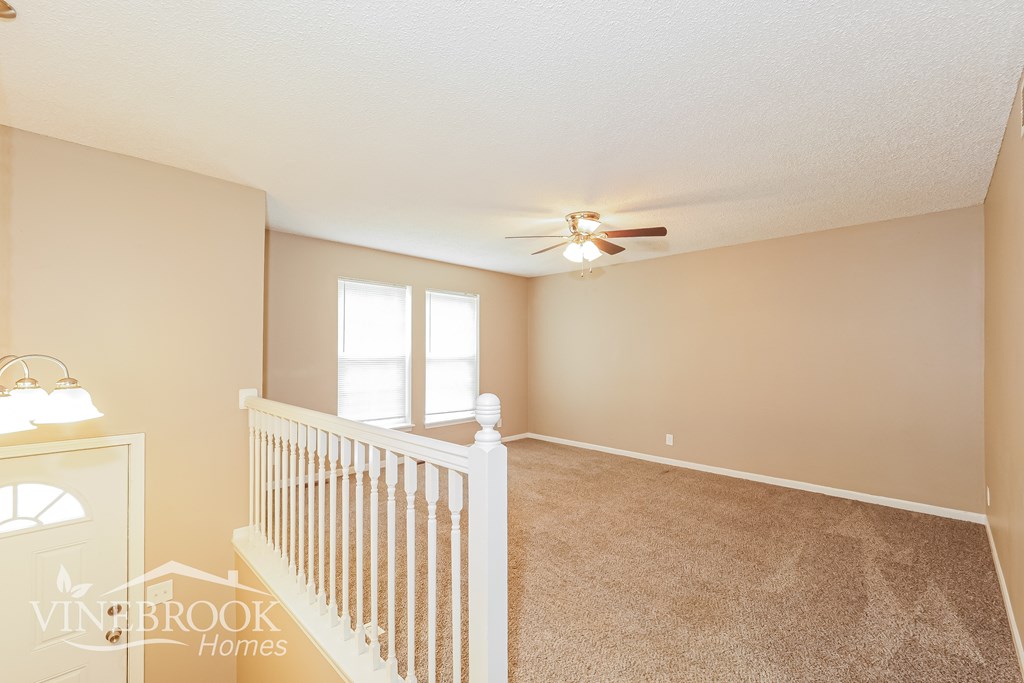 A baby's room with a white crib and a ceiling fan.