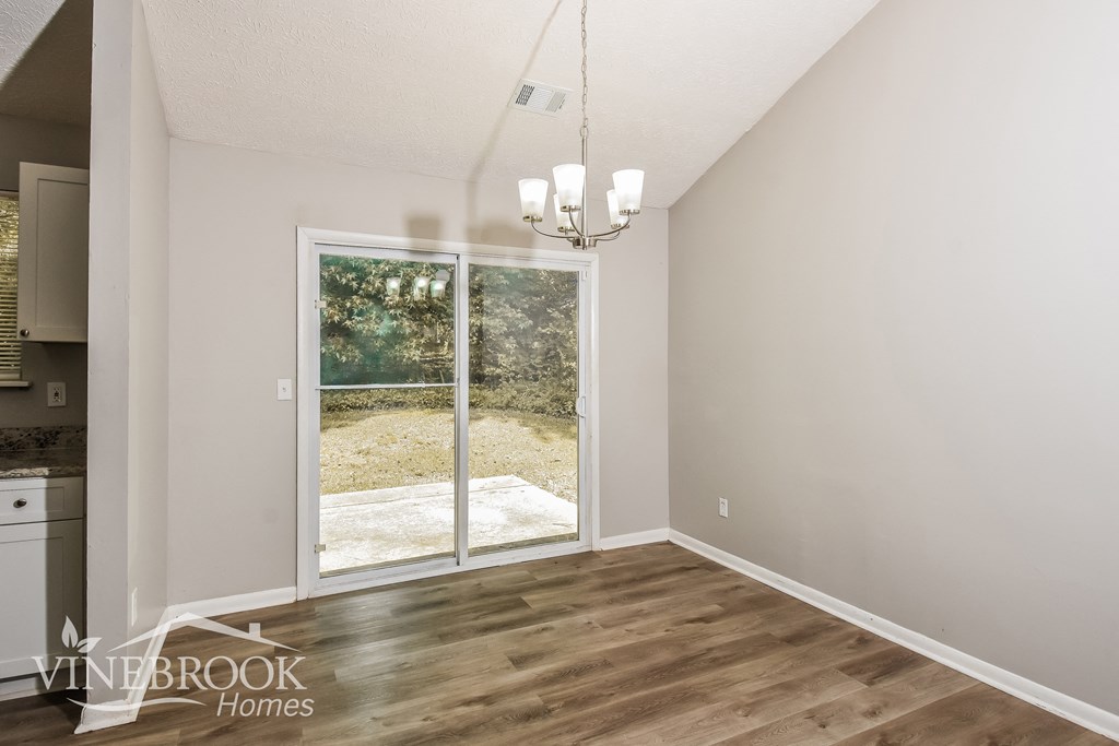 a living room with a sliding glass door to a backyard