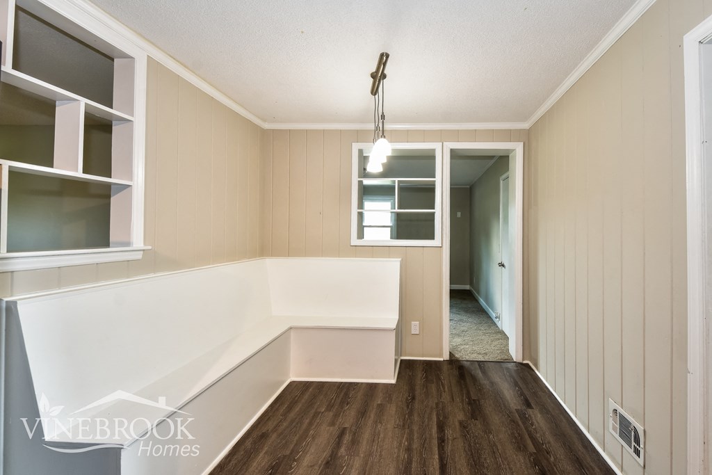 a small kitchen with a white counter top and a window