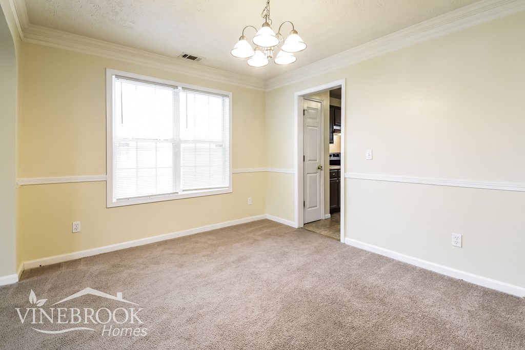 a master bedroom with carpet and a door to the bathroom
