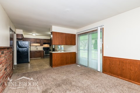 A kitchen with a refrigerator, sink, and cabinets is shown in this image.