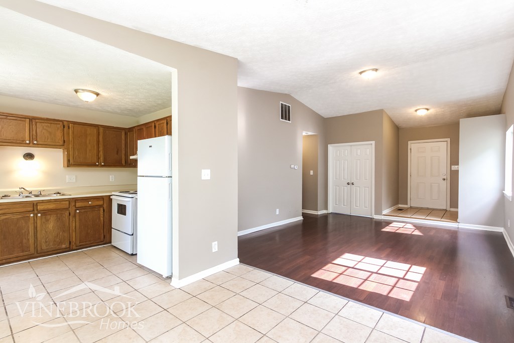 A kitchen with wooden cabinets and a white refrigerator.