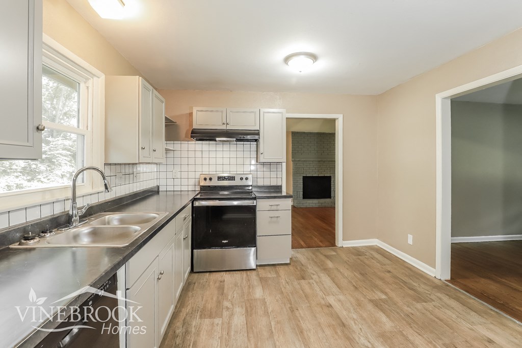 a renovated kitchen with stainless steel appliances and white cabinets