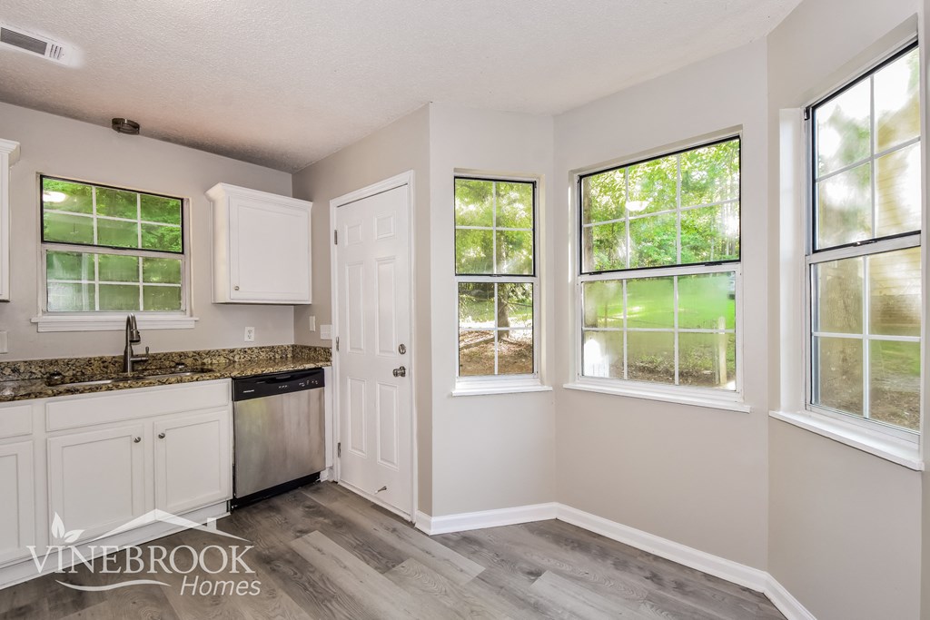 the kitchen of a home with white cabinets and a counter top