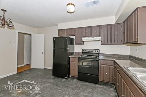 A kitchen with a black refrigerator and stove.