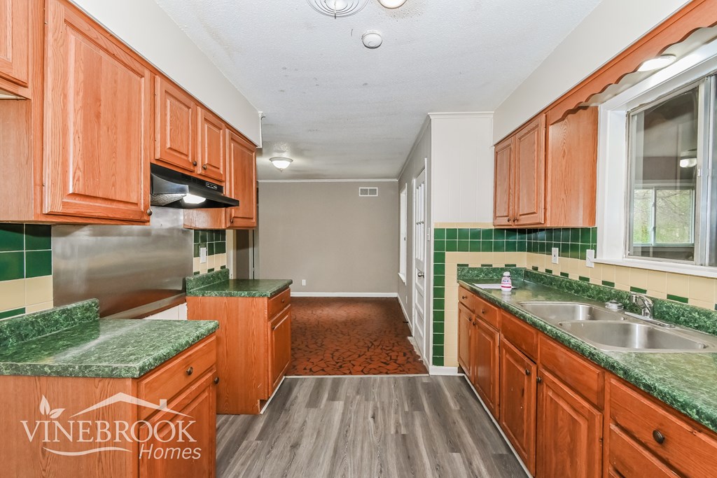 A kitchen with wooden cabinets and green countertops.