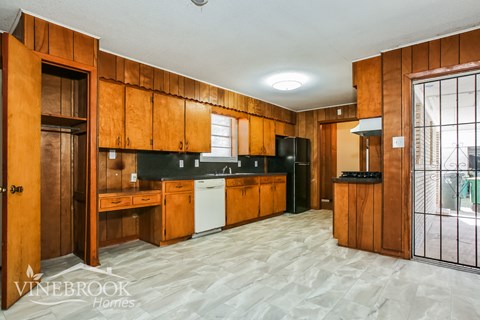 A kitchen with wooden cabinets and a white dishwasher.
