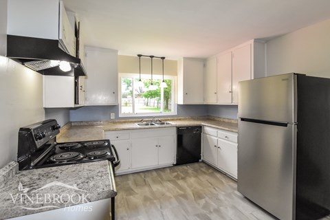 A modern kitchen with stainless steel appliances and white cabinets.