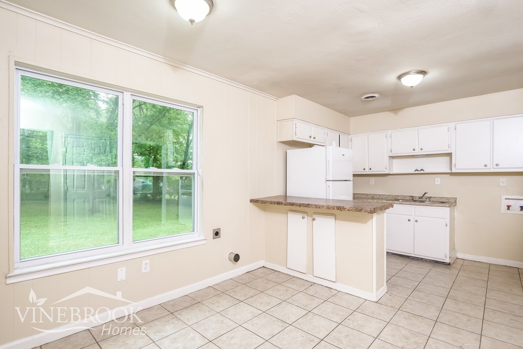 A kitchen with white cabinets and a countertop.