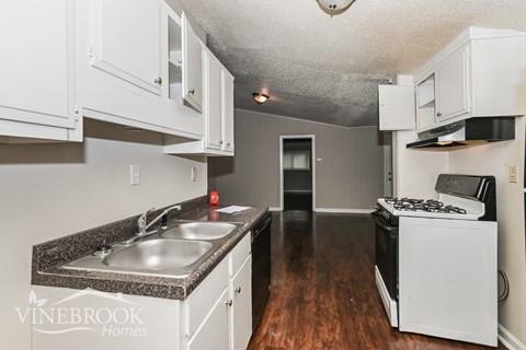 A kitchen with a sink and a stove top oven.