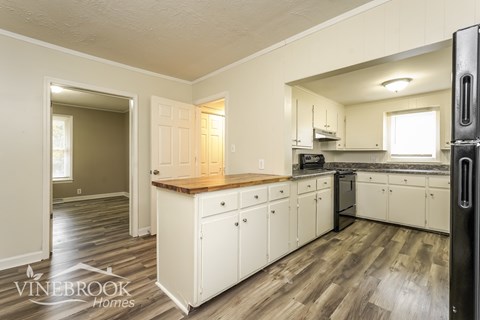 A kitchen with a refrigerator on the right side.