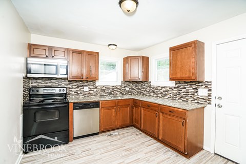 A kitchen with wooden cabinets and a granite countertop.