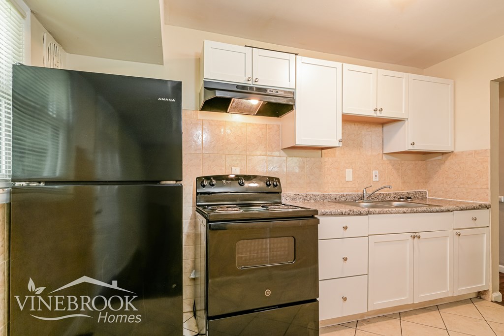 A kitchen with a Vinebrook Homes refrigerator.