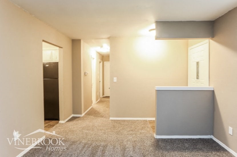 a renovated living room with a hallway to a closet and a door to a bathroom