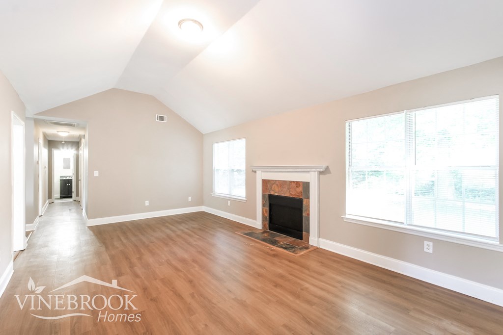 a living room with wood floors and a fireplace