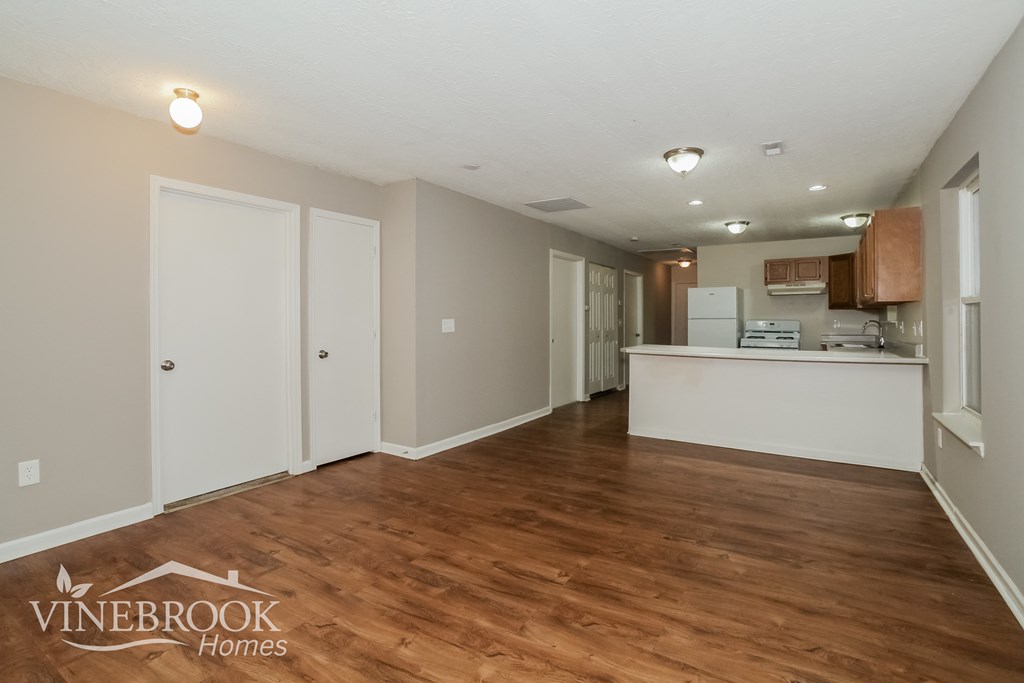 the living room and kitchen of a renovated house with wood flooring