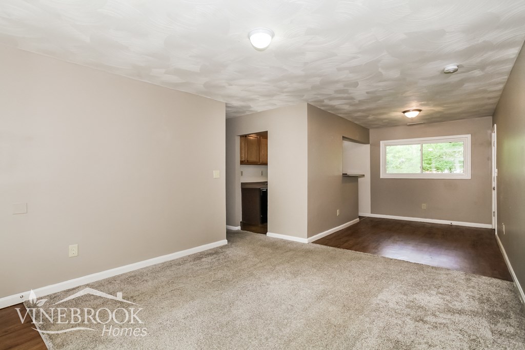 the living room and kitchen of an empty house