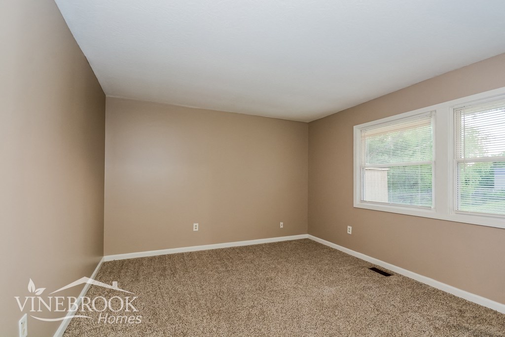 the upstairs bedroom has a carpeted floor and two windows