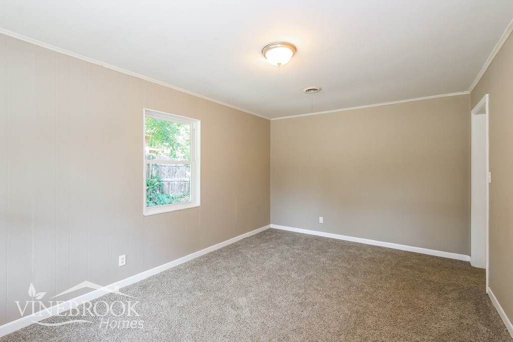 an empty room with carpet and a window