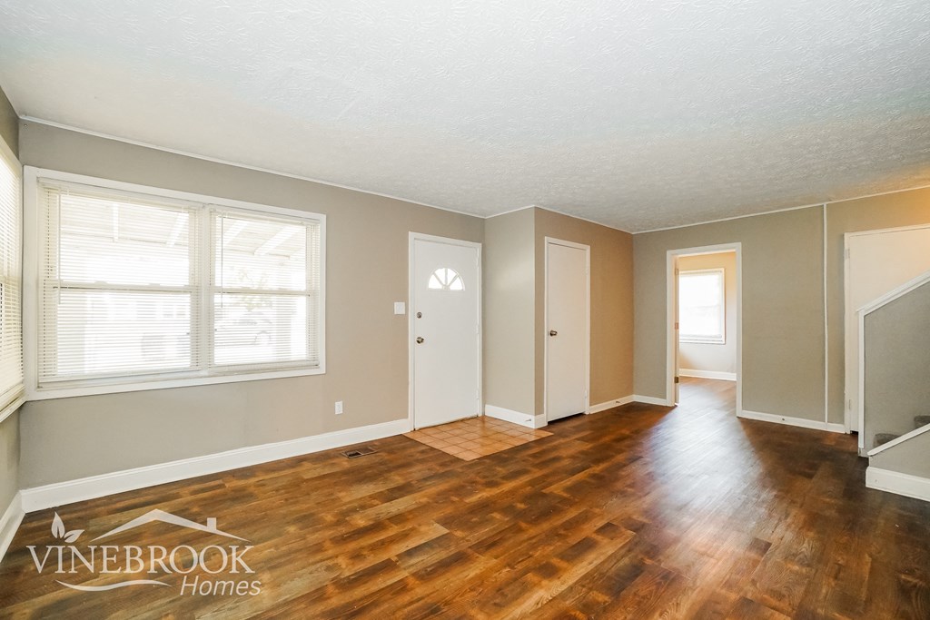 the living room and dining room of a renovated house with wood flooring
