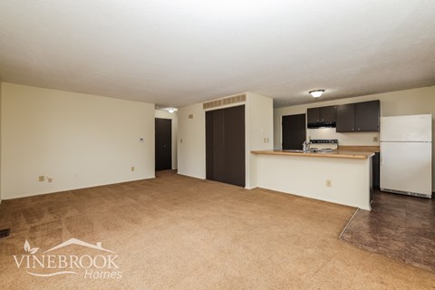 A room with a kitchenette and a refrigerator in it.