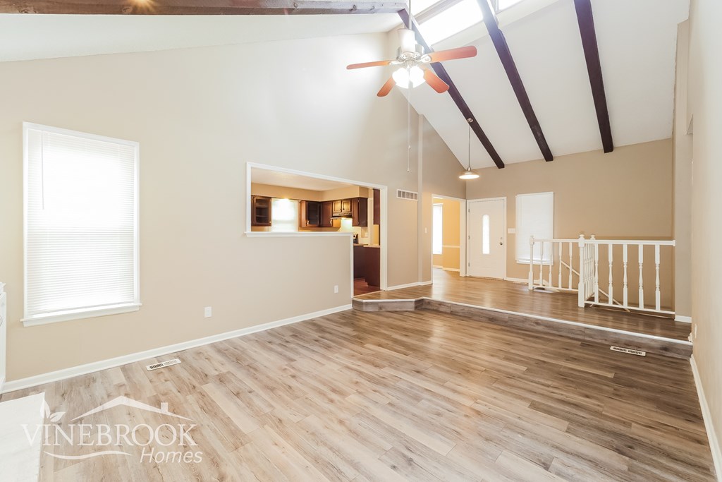 A room with wooden flooring and a ceiling fan.