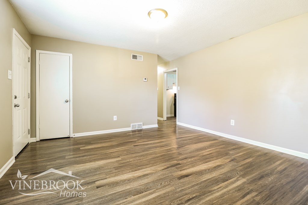 A room with wood flooring and two doors.